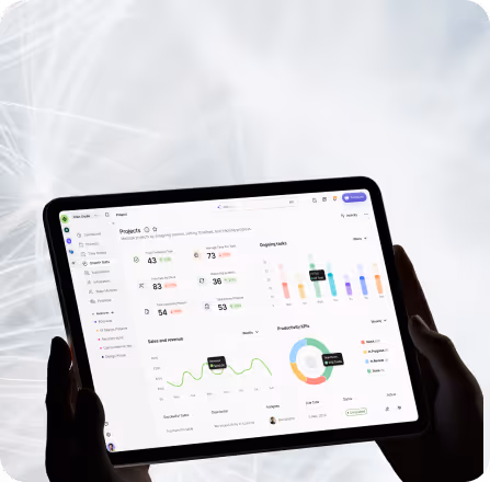 Person holding a tablet displaying a project management dashboard with charts, graphs, and task statistics.