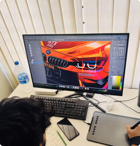 Designer illustrating a car front in graphics software on a desktop computer.