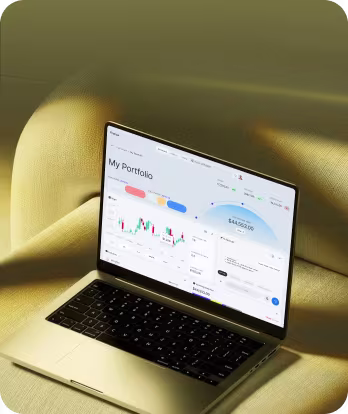 Laptop displaying a portfolio dashboard with charts and financial data on a beige fabric surface.